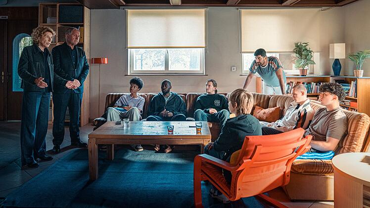 Bibi Fellner (Adele Neuhauser, links) und Moritz Eisner (zweiter von links) reden mit der Wohngruppe "Sonnenhof". Es h&ouml;ren zu, von links: Oki (Yacouba Diabate), Betreuer Femi (Ayo Aloba), Betreuer Simon (Augustin Groz), Levi (Christoph Lackner-Zinner), Betreuer Araz (Emre Cakir), Leon (Tristan Witzel) und Mo (Renas Hussin).