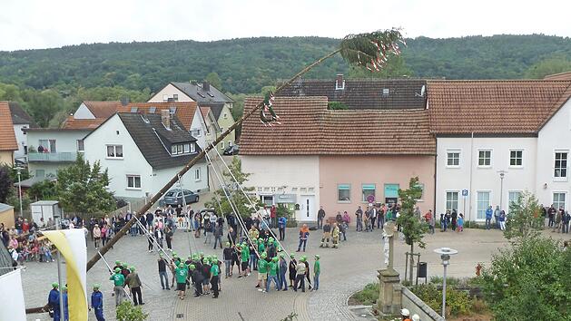 Der 25 Meter hohe Kirchweihbaum wurde mit vereinten Kr&auml;ften der vielen Helfer auf dem Kirchplatz in die Senkrechte gehievt.