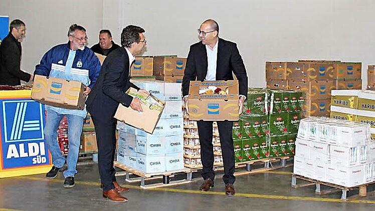 Von links: Michael Thiem, Andy und Jörg (ehrenamtliche Helfer im Lebensmittelpunkt), Markus Steinbrenner und Fabien Busch (Leiter Logistik bei Aldi) bringen die Kisten zum Lieferwagen. Foto: Johanna Blum