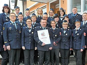 Die Ehrung mit Vorsitzendem Jochen Düsel (l.), Hans Nützel (mit Urkunde) und dahinter die Feuerwehr-Damenmannschaft, die für 20 Jahre Dienst geehrt wurde  Foto: Karl Heinz Wirth
