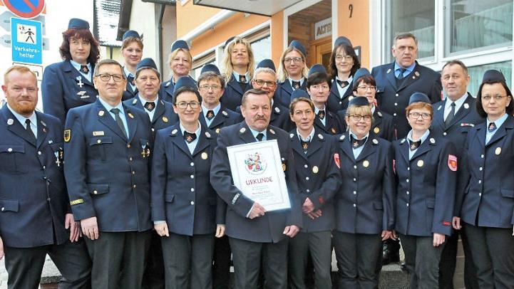 Die Ehrung mit Vorsitzendem Jochen Düsel (l.), Hans Nützel (mit Urkunde) und dahinter die Feuerwehr-Damenmannschaft, die für 20 Jahre Dienst geehrt wurde  Foto: Karl Heinz Wirth