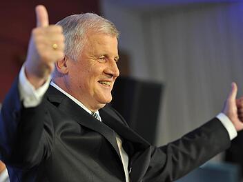Der bayerische Ministerpräsident und CSU-Vorsitzende Horst Seehofer steht in München nach der Bekanntgabe der Hochrechnungen zur Landtagswahl in Bayern mit hochgestreckten Daumen auf dem Podium. Foto: Inga Kjer/dpa