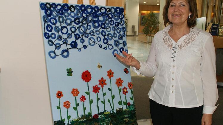 Die Werke, mit denen sich Grund- und Mittelschüler aus dem Landkreis Haßberge an einem bayernweiten Schülerwettbewerb in textilem Gestalten beteiligen, sind bis zum 6. April in der Sparkassen-Galerie in Haßfurt zu sehen. Fachberaterin Barbara Beuerlein, die mit Schulrätin Claudia Schmidt den Wettbewerb initiiert hat, erläutert hier die Techniken, die für das Bild "Frühlingserwachen" angewandt wurden.  Foto: Sabine Weinbeer