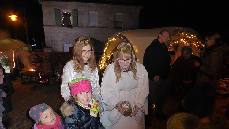 Die Weilersbacher Weihnachtsengel Jana und Lucy mit den  Kindern am Markt Foto: Heidi Amon