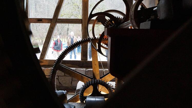 Die historischen Zahnräder drehen sich wieder. Gäste der Einweihung des Mühlrads besichtigen das Anwesen.