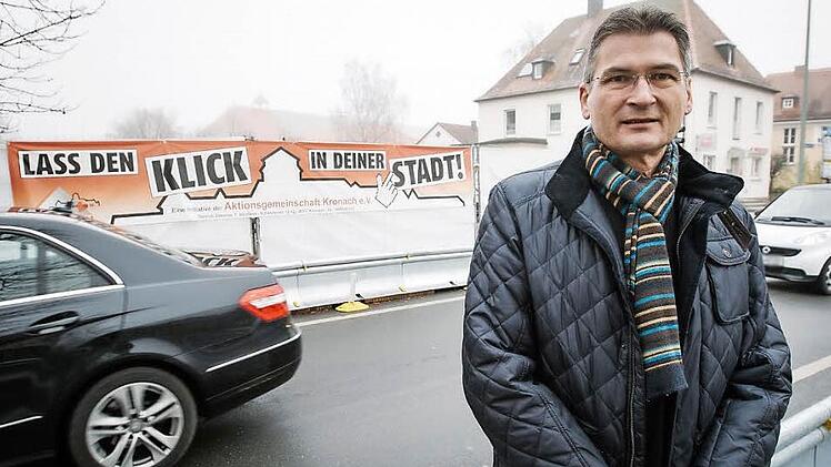Dietrich Denzner steht auf der Kronacher Spitalbrücke vor dem Transparent: "Lass den Klick in Deiner Stadt." Foto: Hendrik Steffens
