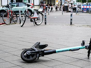 Jungen auf St&uuml;hlen sitzend auf E-Scootern in W&uuml;rzburg unterwegs