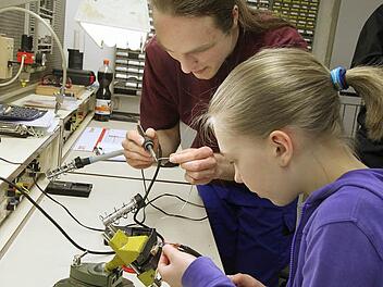 Unter Anleitung von Azubi Michael Ries erledigt Nina Neumayr Lötarbeiten. Für die Schülerin war es das erste Mal, dass sie mit einer solchen technischen Aufgabe betraut wurde. Foto: Heike Beudert