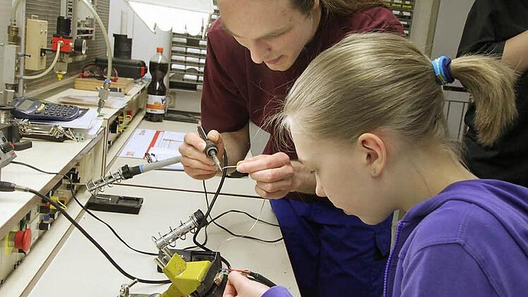Unter Anleitung von Azubi Michael Ries erledigt Nina Neumayr Lötarbeiten. Für die Schülerin war es das erste Mal, dass sie mit einer solchen technischen Aufgabe betraut wurde. Foto: Heike Beudert