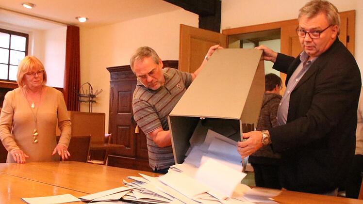 Die Wahlhelfer Christl Pottler, Dietmar Herrnleben und Anton Aumüller (von links) in Zeil leeren kurz nach Schließung der Wahllokale am Wahl-Sonntag um 18 Uhr den Behälter mit den Stimmzetteln aus. Kurz darauf beginnt die Stimmzählung.Andreas Lösch