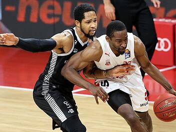 Duell der beiden Topscorer:  Jordan Crawford (rechts), mit 21 Punkten bester Bamberger Werfer, lässt sich von Vechtas Trevis Simpson (28 Punkte) nicht stoppen. Foto: Daniel Löb/Pool via Heiko Becker/HMB Media