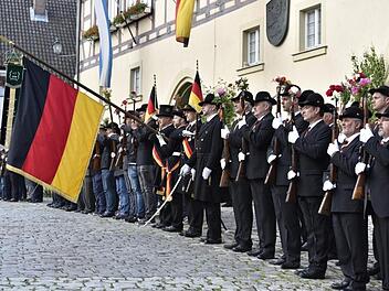 Die Bürgerwehr ist angetreten vor dem Rathaus: Es geht den Teilnehmern am Auszug unter die Haut, wenn sich die Bürgerwehrfahne zum Lied vom Kameraden senkt. Die Blumen an den Gewehren oder Spazierstücken sollen den friedlichen Charakter der Aktion dokumentieren.