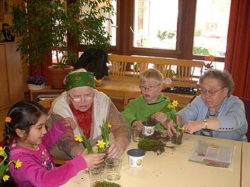 Margit Bayerlein (2. v.l.) und Eleonore Backert (rechts) pflanzten mit ihren Freunden vom Montessori-Kindergarten Dörfles Narzissen in Gläser.  Foto: Heike Schülein