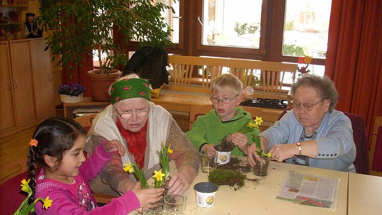 Margit Bayerlein (2. v.l.) und Eleonore Backert (rechts) pflanzten mit ihren Freunden vom Montessori-Kindergarten Dörfles Narzissen in Gläser.  Foto: Heike Schülein