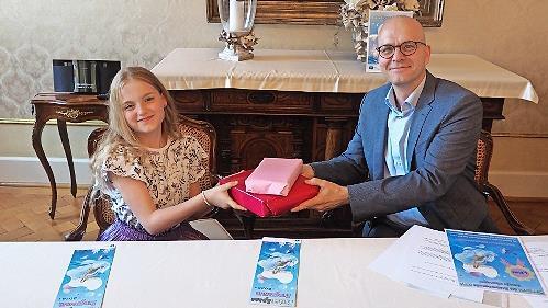 Oberbürgermeister Dirk Vogel gratulierte der Siegerin des Malwettbewerbs für das Ferienprogramm Rosalie Nürnberger.