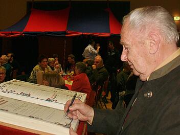 Ehrenmitglied Josef Schmitt trägt sich ins Goldene Buch des Heimatvereins ein. Foto: Werner Vogel