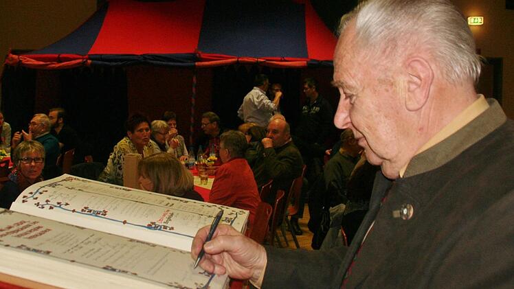 Ehrenmitglied Josef Schmitt trägt sich ins Goldene Buch des Heimatvereins ein. Foto: Werner Vogel