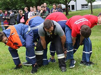 Die Feuerwehr Großheirath als Spinne - Elmar Butterhof mit dem Baumstamm - Ein Traktorreifen musste über das Spielfeld trasporterit werden. Die Mannschaften traten gegeneinander auf drei Bahnen an. Foto: Michael Stelzner