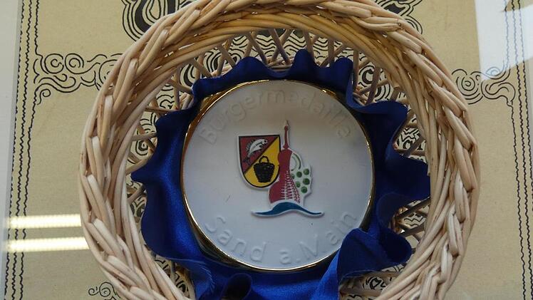 Die Bürgermedaille der Gemeinde Sand wurde von Ernst Albert entworfen und in einer Porzellanfabrik hergestellt. Christian Licha