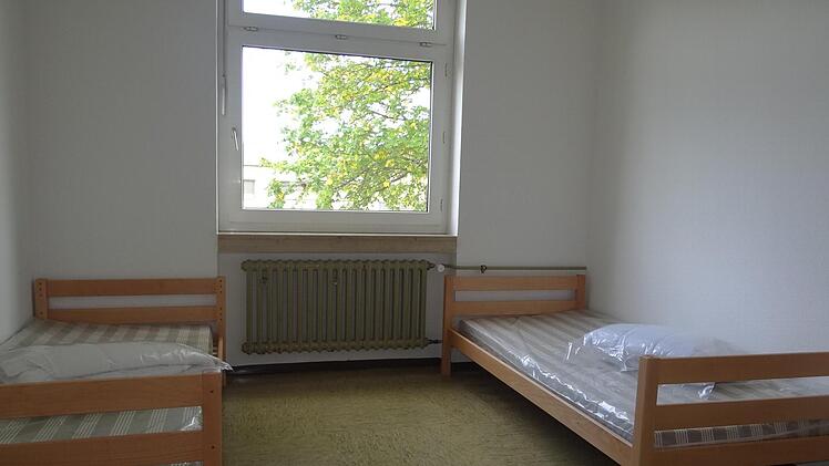 Der Blick in und aus einem Zweibettzimmer in der Gemeinschaftsunterkunft in Ebern. Kahle Wände empfangen die asylsuchenden Menschen. Bett, Stuhl, Tisch, Schrank und Kühlschrank gehören zur Grundausstattung der Möbeleinrichtung. Foto: Johanna Eckert
