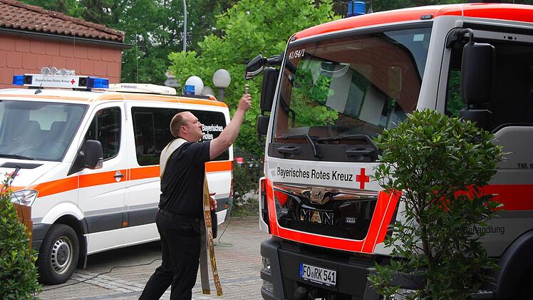 Kaplan Gerd-Richard Neumeier segnet die beiden neuen Fahrzeuge, die aus eigenen Mitteln des BRK und Geldern vom Bund angeschafft werden konnten. Foto: Gerhard Hoch