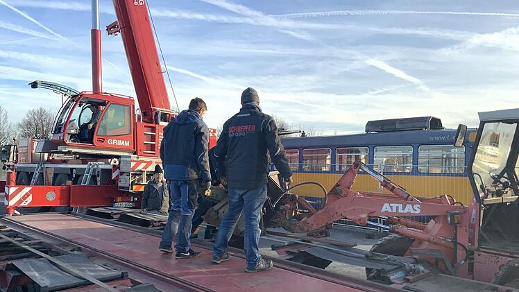 Ein Autokran hat die 18 Tonnen schwere Straßenbahn vom Tieflader hoch gehoben und sie behutsam auf die extra dafür gelegten Schienen gesetzt.
