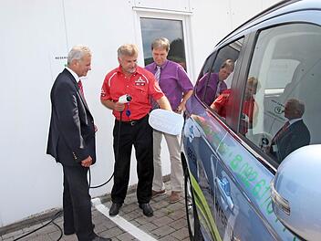 Sie lassen sich das Tanken aus der Steckdose erklären: Landrat Oswald Marr und Bürgermeister Klaus Löffler mit dem Geschäftsführer des Autohauses Fröba, Raimund Fröba. Foto: Veronika Schadeck