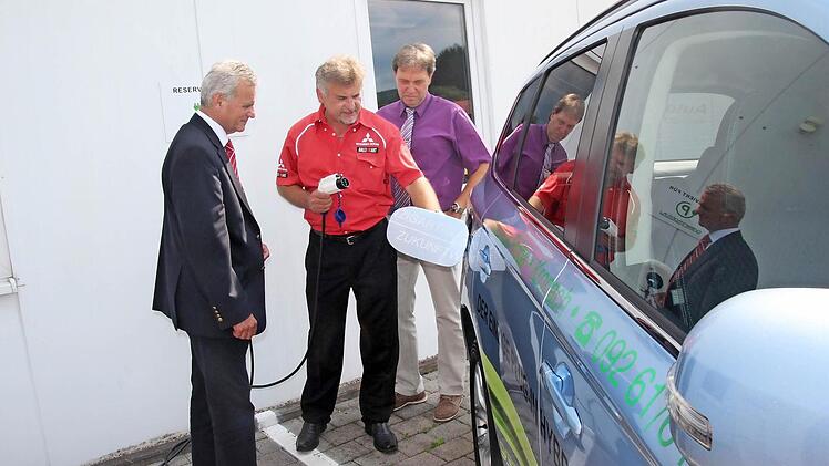 Sie lassen sich das Tanken aus der Steckdose erklären: Landrat Oswald Marr und Bürgermeister Klaus Löffler mit dem Geschäftsführer des Autohauses Fröba, Raimund Fröba. Foto: Veronika Schadeck