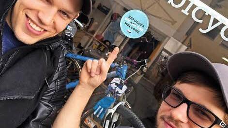 Daniel von Stefani (l.) freut sich darüber, dass André Joffroy den Aufkleber an das Fenster seines Erlanger Fahrradladens angebracht hat.