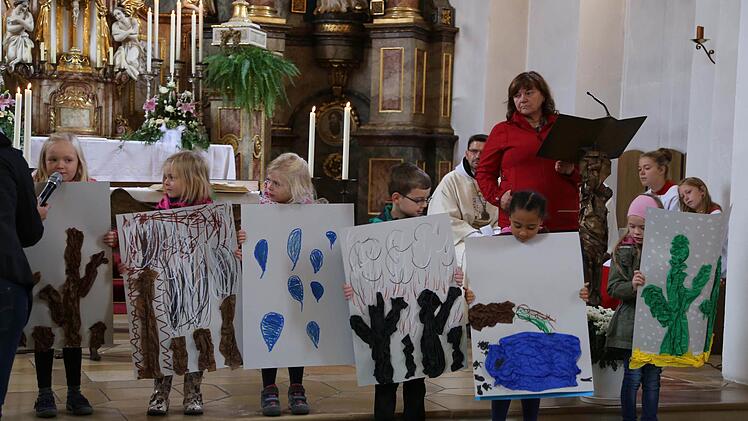 Die Kinder zeigen Plakate, auf denen eine zerstörte Umwelt dargestellt ist. Foto: Franz Galster