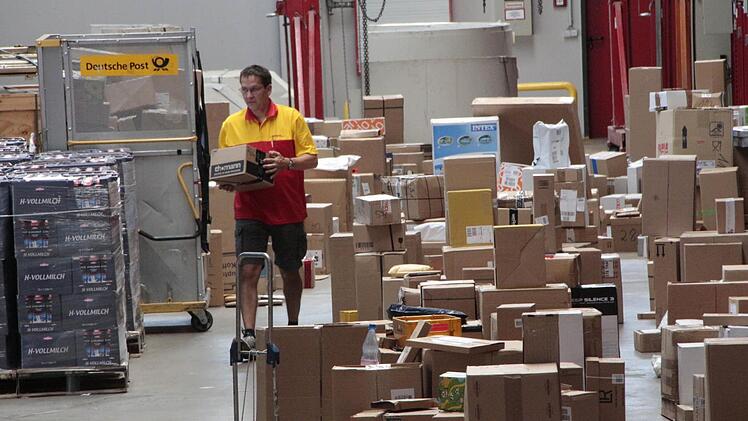 Mitarbeiter der Post haben alle Hände voll zu tun, die Pakete an die Selbstabholer in der Hegele-Halle auszuliefern.  Foto: Josef Hofbauer
