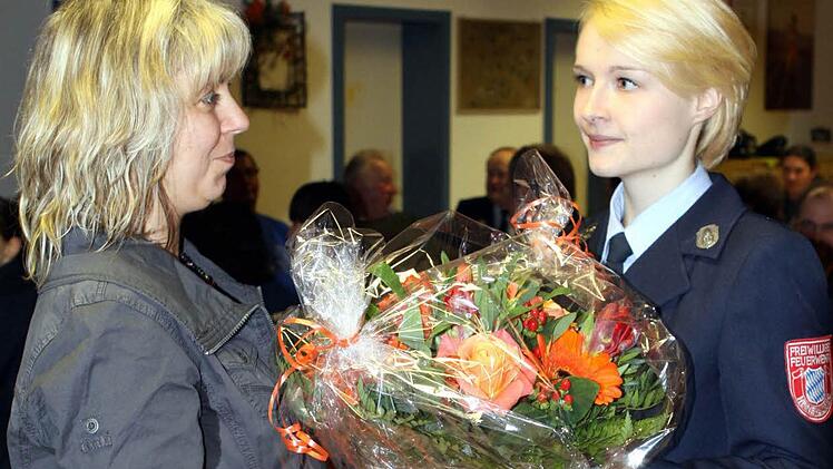 Die bisherige Vorsitzende der Feuerwehr Heinersberg, Tanja Hagen (rechts), überreichte an ihre Nachfolgerin Kirstin Fischer einen Blumenstrauß für die Bereitschaft, sich der Aufgabe als Vorsitzende der Feuerwehr zu stellen. Foto: Michael Wunder