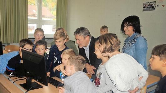 Begeistert erklären die Schüler Bürgermeister Gerhard Wunder die neuen Computer und Monitore. Rechts Förderlehrerin Birgit Gold.  Foto: Susanne Deuerling