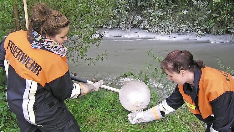 Die beiden Feuerwehrdamen Julia Müller (links) und Steffi Felber nahmen eine Wasserprobe aus der verunreinigten Kleinen Weisach. Foto: Andreas Dorsch