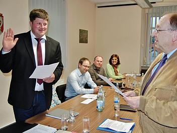 Alexander Schneider (UWG, links) wird von Ratsmitglied Fred Hilsdorf (FWG) vereidigt: im Hintergrund die neuen Gemeinderäte (von links) Steffen Schneider (PWG, Zweiter Bürgermeister), Holger Knauer (PWG) und Monika Bienmüller (UWG). Foto: Sigismund von Dobschütz