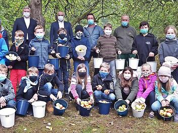 Auf der Streuobstwiese hinter der Grundschule sammelten Mädchen und Jungs der Klasse 4 a Äpfel auf. Obst, aus dem leckerer Saft werden soll. Über den Eifer der Kinder freuen sich (von links) Bankvorstand Thomas Siebenaller, Bürgermeister Robert Hümmer, Rektor Stefan Kern und Hausmeister Lorenz Nastvogel. Foto: Bernd Kleinert