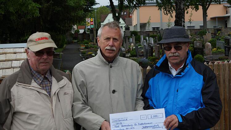 Josef Merz (links) und Wolfgang Eilingsfeld (rechts) unterstützen den Friedhof mit einer Spende an Ernst Stross.