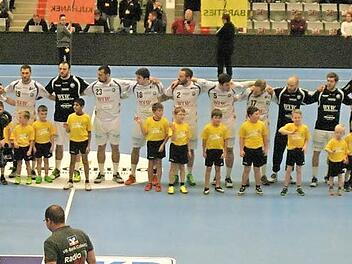 Kurz vor dem Anpfiff steht ein Teil der Windheimer Nachwuchsfu&szlig;baller mit den Spielern des Bergischen HC auf dem Feld. Foto: Iris Bilek