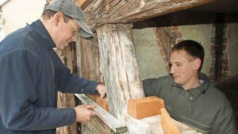 Helfer richten derzeit das Nebengebäude her. Auf unserem Bild mauern Matthias Völkel (links) und Peter Kuhn ein Fachwerk neu aus.