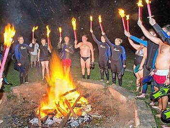 Mit dem Schlachtruf der Lichtenfelser Wasserwacht wurden die Fackeln nach dem Schwimmen ins Feuer geworfen.