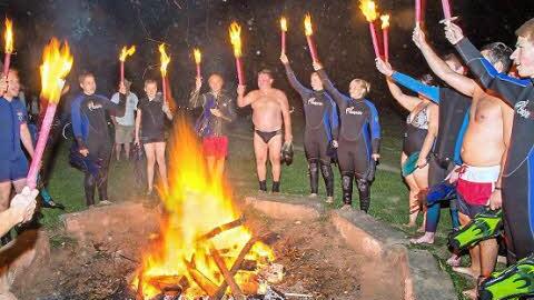 Mit dem Schlachtruf der Lichtenfelser Wasserwacht wurden die Fackeln nach dem Schwimmen ins Feuer geworfen.