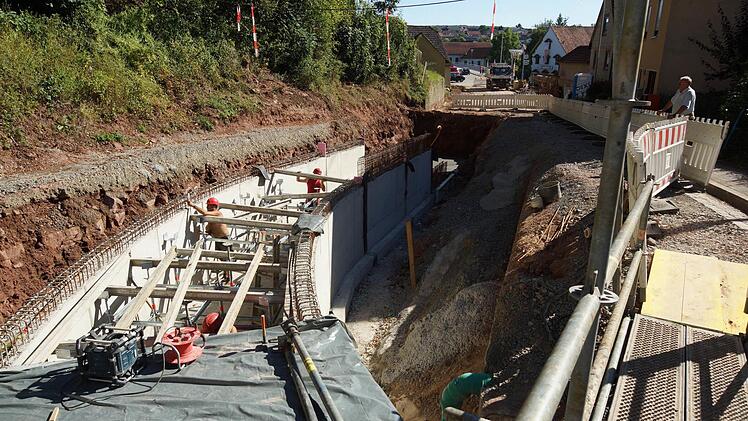 Der Schrenkgraben in Aura bekommt einen neuen Bachlauf. Im Sommer beginnen die Bauarbeiten, um den Wildbach unter der Straße auf die andere Seite zu verlegen. Arbeiter bauen das Kastenprofil für den Bachlauf. Foto: Arkadius Guzy