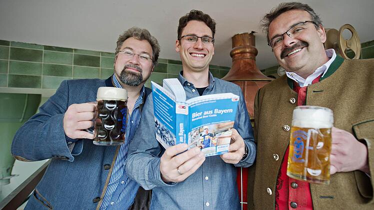 Die beiden Autoren des Buches "Bier aus Bayern - Bavarian Beer Guide", Markus Raupach (von links) und Bastian Böttner, stehen in München (Bayern) zusammen mit dem Besitzer der "Forschungsbrauerei", Manfred Silbernagl, vor einem Sudkessel. Laut den Verfassern wurden für die "Bier-Bibel" erstmals alle bayerischen Brauereien unter die Lupe genommen und auf ihre Besonderheiten untersucht. Foto: Nicolas Armer/dpa