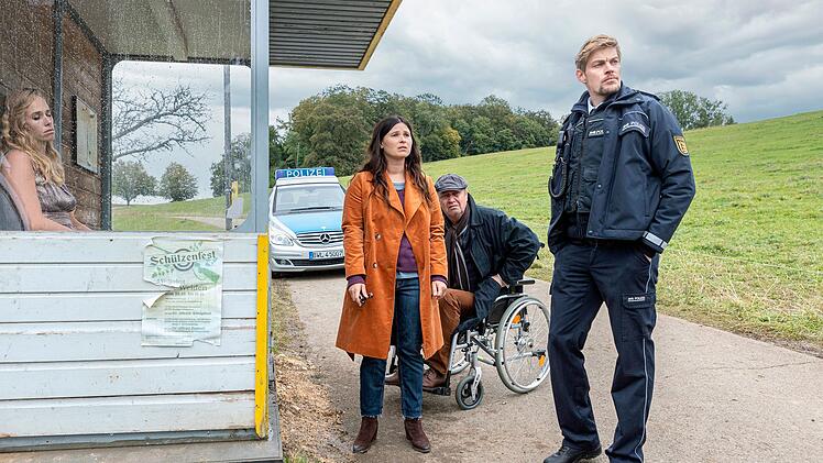 Viermal fuhr der Bus an ihr vorbei: Eine Tote sitzt an der Bushaltestelle. Lisa (Anna Fischer) und ihr Vater Alfons (Artus Maria Matthiesen, zweiter von rechts) wollen wissen, um wen es sich handelt. Der Polizist Andi Kuhn (Helgi Schmid) zeigt sich eher desinteressiert.