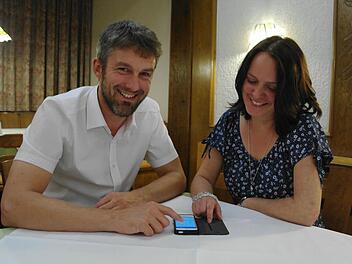 Mottens Bürgermeister Jochen Vogel zeigt seine Begeisterung über den Online-Service seines Rathauses auf dem Smartphone der Gemeinderätin Bettina Kraus.  Foto: Stephanie Elm