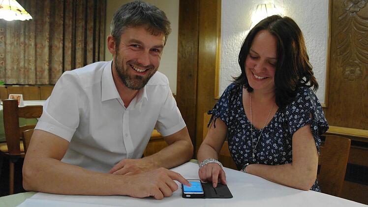 Mottens Bürgermeister Jochen Vogel zeigt seine Begeisterung über den Online-Service seines Rathauses auf dem Smartphone der Gemeinderätin Bettina Kraus.  Foto: Stephanie Elm