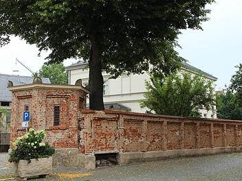 Auch die denkmalgeschützte Mauer ums Pfarrhaus wird neu bedacht und verputzt. Die Wurzeln der Linde (Mitte) sollen noch mehr Platz bekommen. Foto: Andreas Dorsch