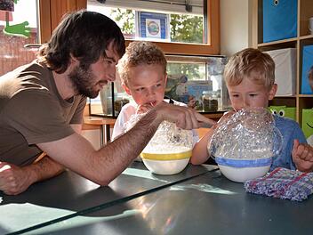 Seifenblasen können auch eckig sein. Das entdecken hier Hannes (rechts) und Max. Sie unterhalten sich mit Stephan Rinke darüber. Der Sozialpädagoge hat nicht nur die Auszeichnung überbracht, sondern lässt sich von den Kindern auch Experimente zeigen. Foto: Kathrin Kupka-Hahn