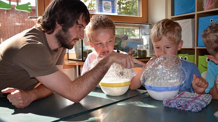 Seifenblasen können auch eckig sein. Das entdecken hier Hannes (rechts) und Max. Sie unterhalten sich mit Stephan Rinke darüber. Der Sozialpädagoge hat nicht nur die Auszeichnung überbracht, sondern lässt sich von den Kindern auch Experimente zeigen. Foto: Kathrin Kupka-Hahn