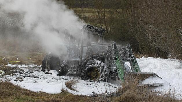 Nicht der erste Schnee sondern Löschschaum: Trotz des Einsatzes der Feuerwehr ist der Traktor bei Knetzgau ausgebrannt. Foto: Christiane Reuther